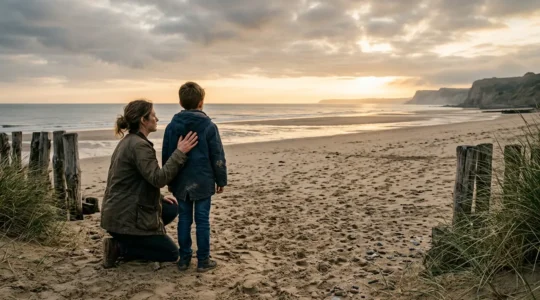 Famille debout sur une plage de Normandie face à la mer, parent et enfant contemplant l'horizon