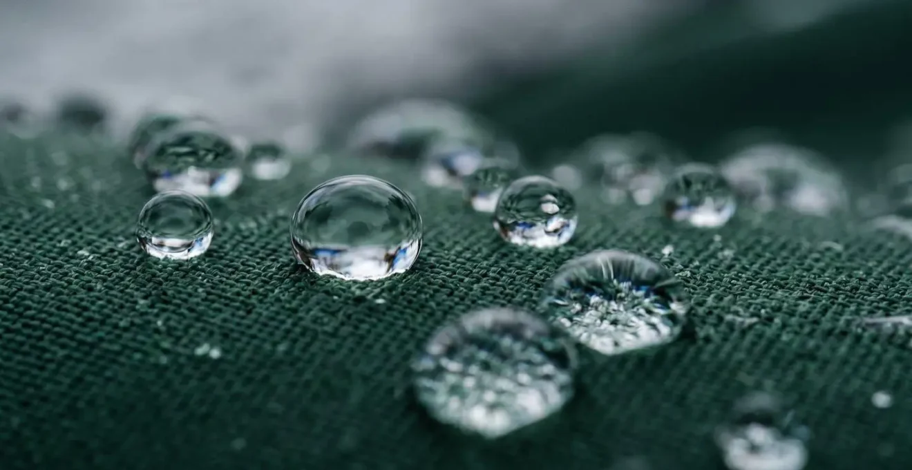Détail macro de gouttes d'eau perlant sur tissu imperméable