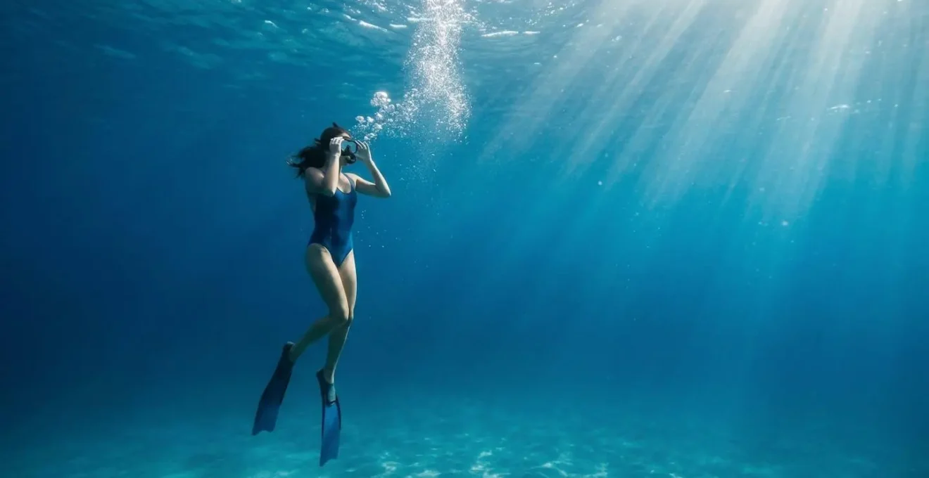 Plongeur en train d'ajuster son masque de snorkeling sous l'eau avec des bulles d'air visibles
